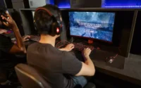 menino em lanhouse usando acessórios para pc