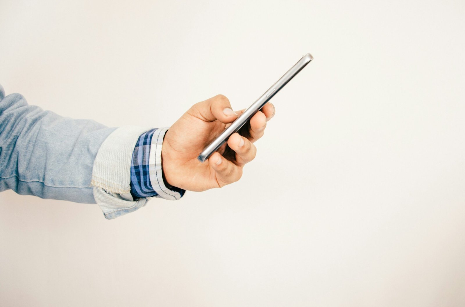 homem segurando celular na mão