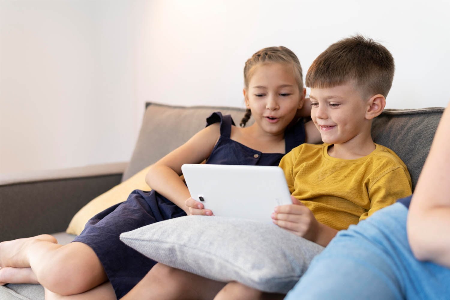 menina e menino se divertindo com tablet infantil