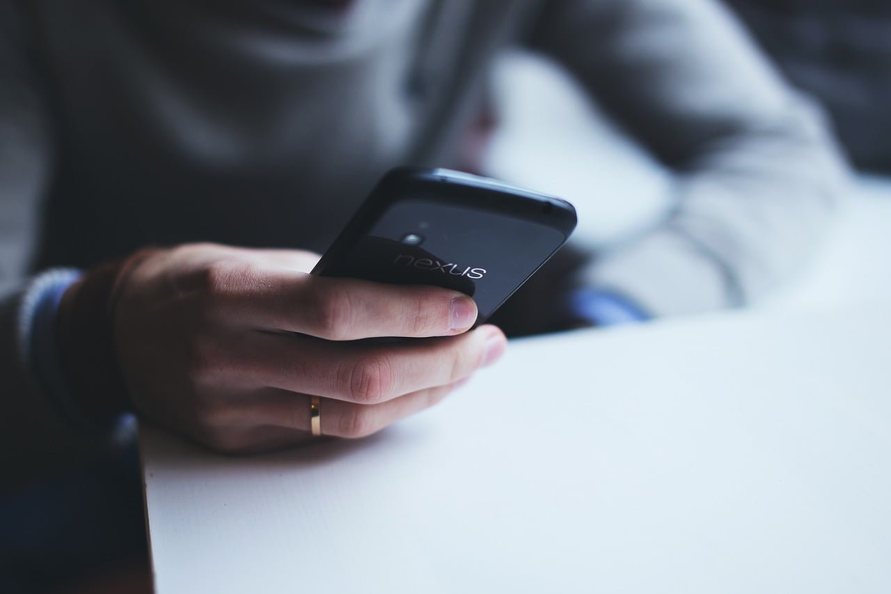 homem segurando celular com bom custo-benefício