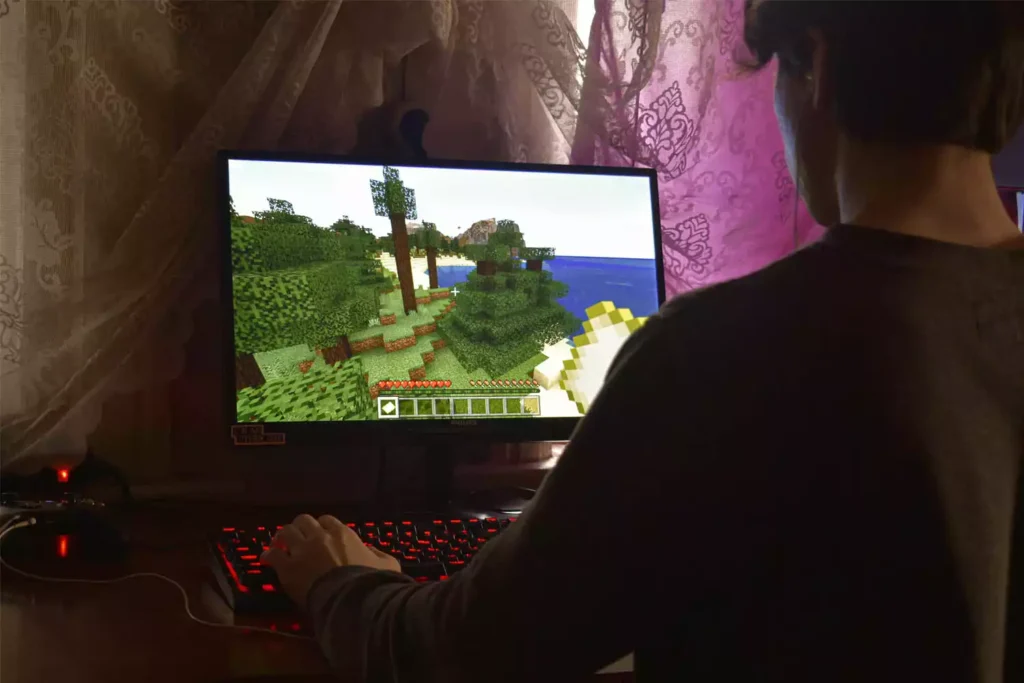 Menino jogando minecraft com acessórios para games de PC