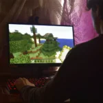 Menino jogando minecraft com acessórios para games de PC