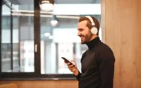 Homem com celular na mão usando fones de ouvido Bluetooth da Philips