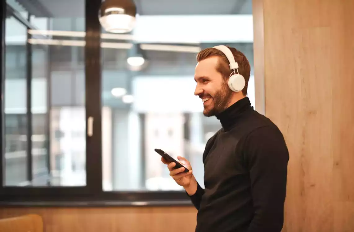 Homem com celular na mão usando fones de ouvido Bluetooth da Philips