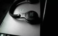 Um dos fones de ouvido sem fio da JBL em cima de notebook