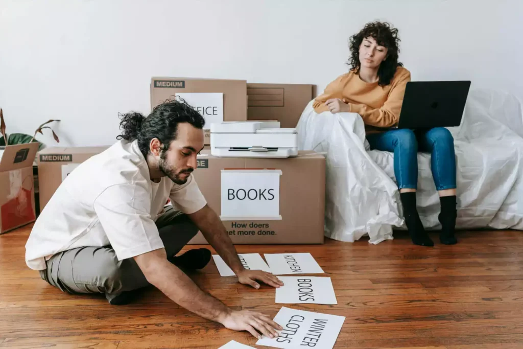 Moça sentada no sofá com notebook e moço sentado no chão usando uma impressora Epson