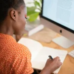 Moça anotando dicas para escolher o melhor teclado para PC