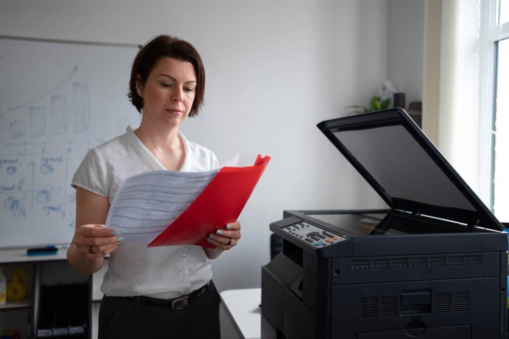 mulher escolhendo documentos para scanear ao lado de impressora HP