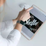 Mulher usando galaxy watch 4 enquanto mexe em tablet