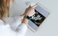 Mulher usando galaxy watch 4 enquanto mexe em tablet