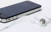 Celular plugado com fone de ouvido e conectado com adaptador de fone de ouvido