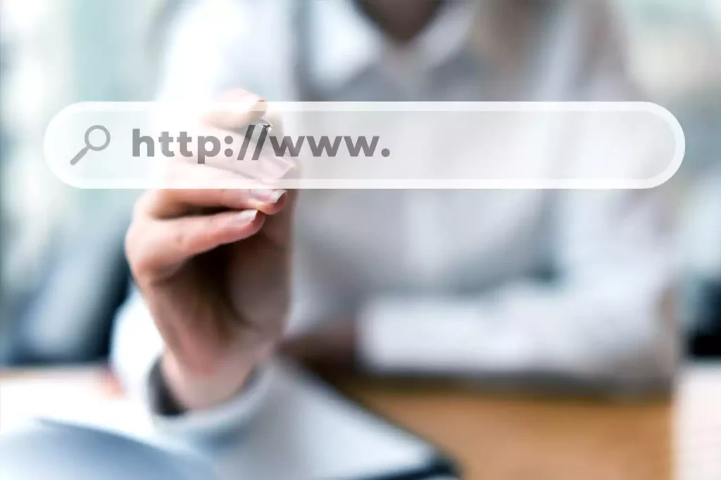 dominio-de-site-gratuito Mulher sentada apontando para a tela e mostrando um domínio gratuito
