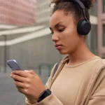 Moça ouvindo musica no celular com fone de ouvido bluetooth