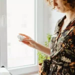 Moça segurando um par de fones de ouvido Bluetooth Xiaomi