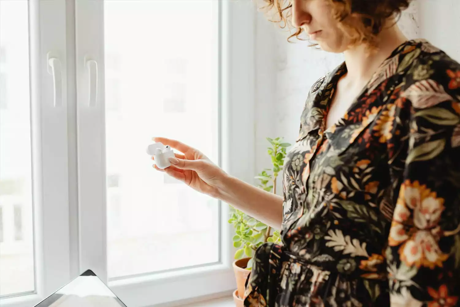 Moça segurando um par de fones de ouvido Bluetooth Xiaomi