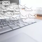 Notebook aberto com várias figuras de envelopes indicando o serviço de e-mail