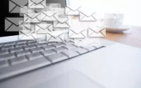Notebook aberto com várias figuras de envelopes indicando o serviço de e-mail