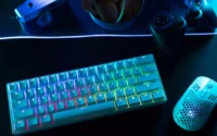Teclado iluminado para PC ao lado de mouse em cima de uma escrivaninha