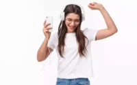 moça ouvindo musica em fone de ouvido ligado a adaptador de fone lighthing em um iPhone
