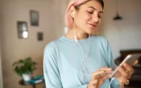 moça ouvindo musica em fone de ouvido com adaptador de fone de ouvido iPhone em celular Android