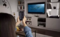moça apontando celular para smart tv de 40 polegadas