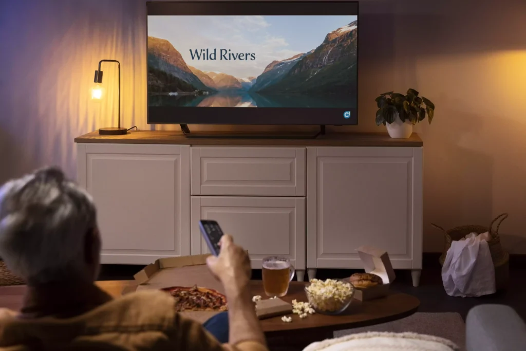 moço deitado no sofá assistindo série em smart tv de 55 polegadas