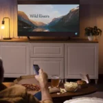 moço deitado no sofá assistindo série em smart tv de 55 polegadas
