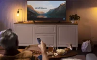 moço deitado no sofá assistindo série em smart tv de 55 polegadas