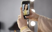 moça segurando celular com câmera boa e tirando uma selfie