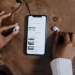 pessoa apanhando um par de fone de ouvido TWS