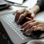 mulher usando notebook buscando as melhores hospedagens de sites