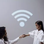 mulher segurando mão da filha que está usando um smartwatch infantil