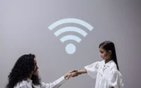 mulher segurando mão da filha que está usando um smartwatch infantil