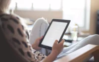 moça sentada olhando tablet barato