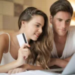 casal sentados e frente a notebook buscando notebooks em promoção