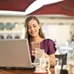 moça sentada em frente ao notebook buscando promoção de celular