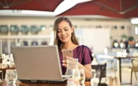 moça sentada em frente ao notebook buscando promoção de celular