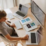 homem sentado em frente escrivaninha usando computador da Lenovo