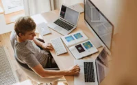 homem sentado em frente escrivaninha usando computador da Lenovo