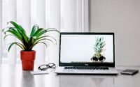 notebook sobre uma mesa em escritório home office ao lado da janela