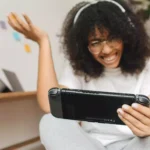 moça se divertindo ao jogar videogame portátil