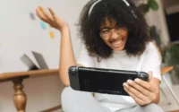 moça se divertindo ao jogar videogame portátil