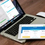 notebook aberto com tablet em cima com a tela mostrando plano de hospedagem de loja virtual
