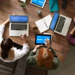 pessoas em escritório usando as melhores marcas de notebook