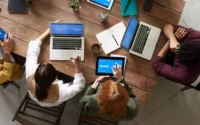 pessoas em escritório usando as melhores marcas de notebook