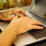 mãos de homem usando um dos notebooks da Asus