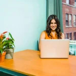 moça sentada em escritório home office usando um dos notebooks com placa de vídeo
