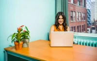 moça sentada em escritório home office usando um dos notebooks com placa de vídeo