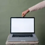 mão de mulher tocando um dos notebooks com tela touch screen