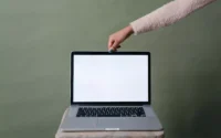 mão de mulher tocando um dos notebooks com tela touch screen